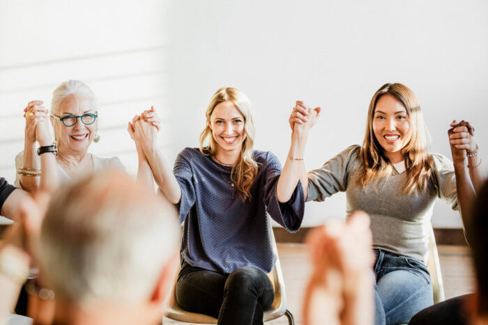Group of diverse people holding hands up in the ai MAJ7XT5 1.jpg
